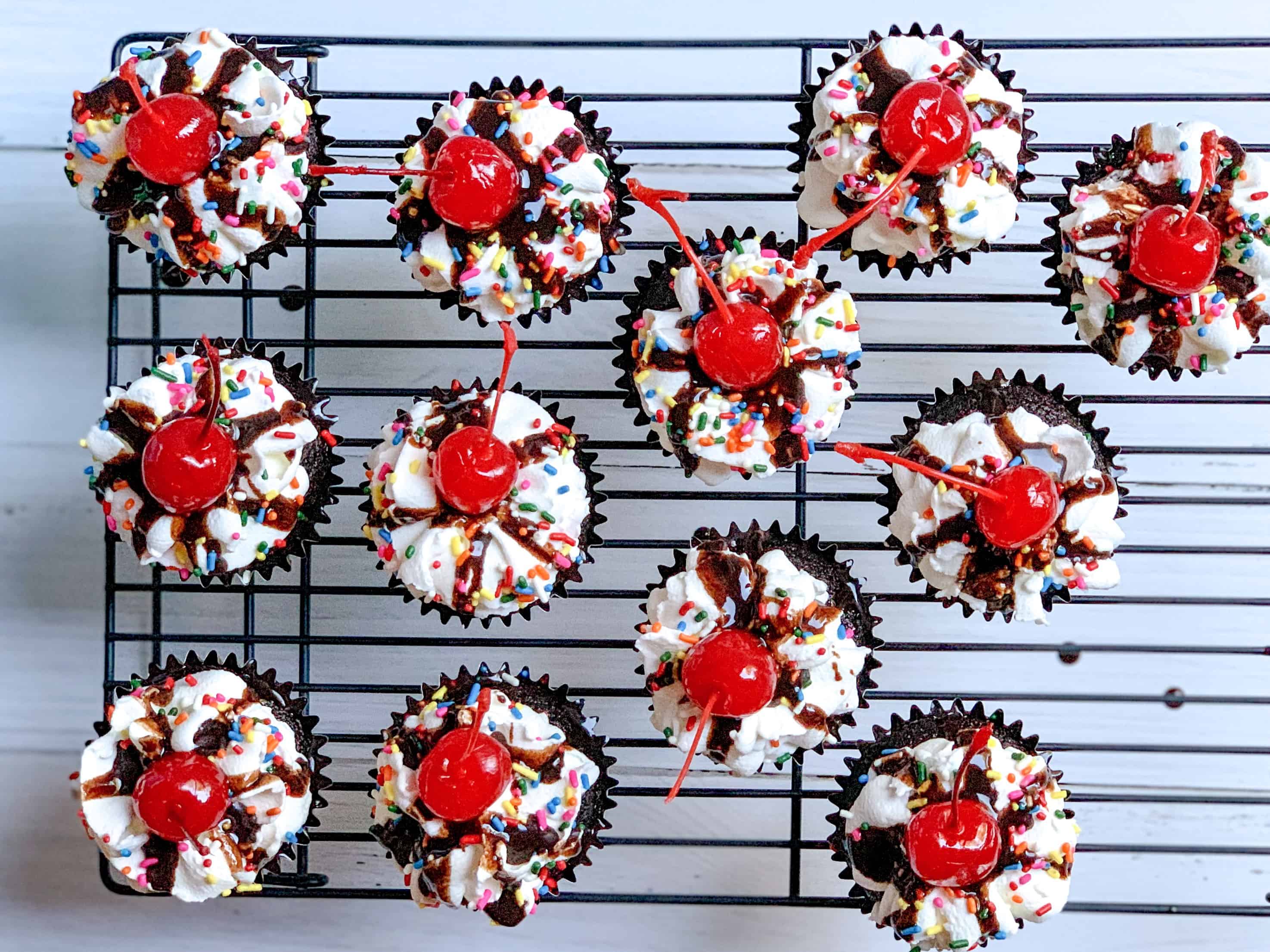 aerial view of 12 cupcakes on black cooling rack. 