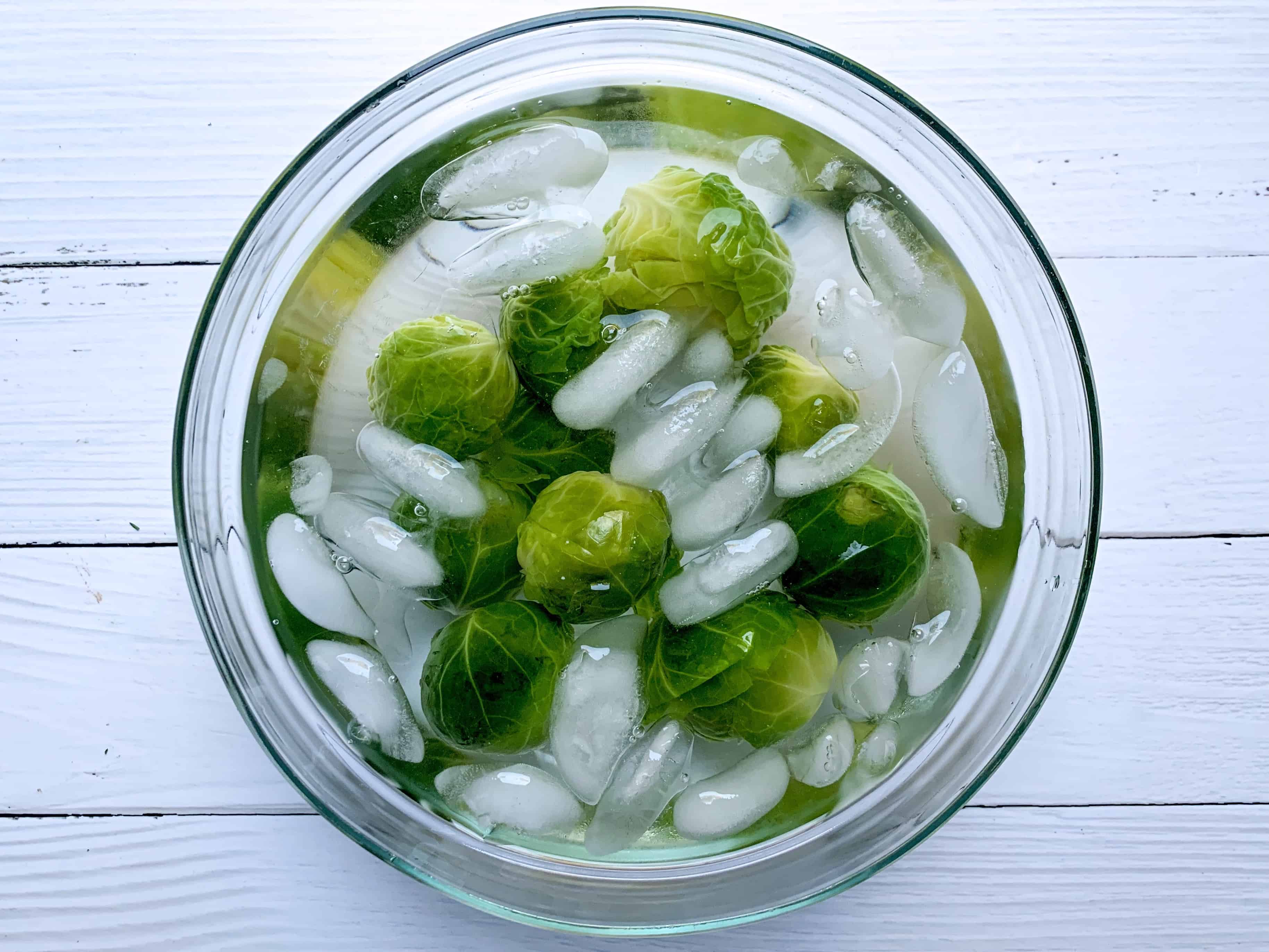 brussel sprouts blanching in cold water after having been boiled. 