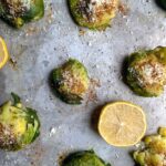 roasted brussels sprouts on sheet pan with half a lemon.