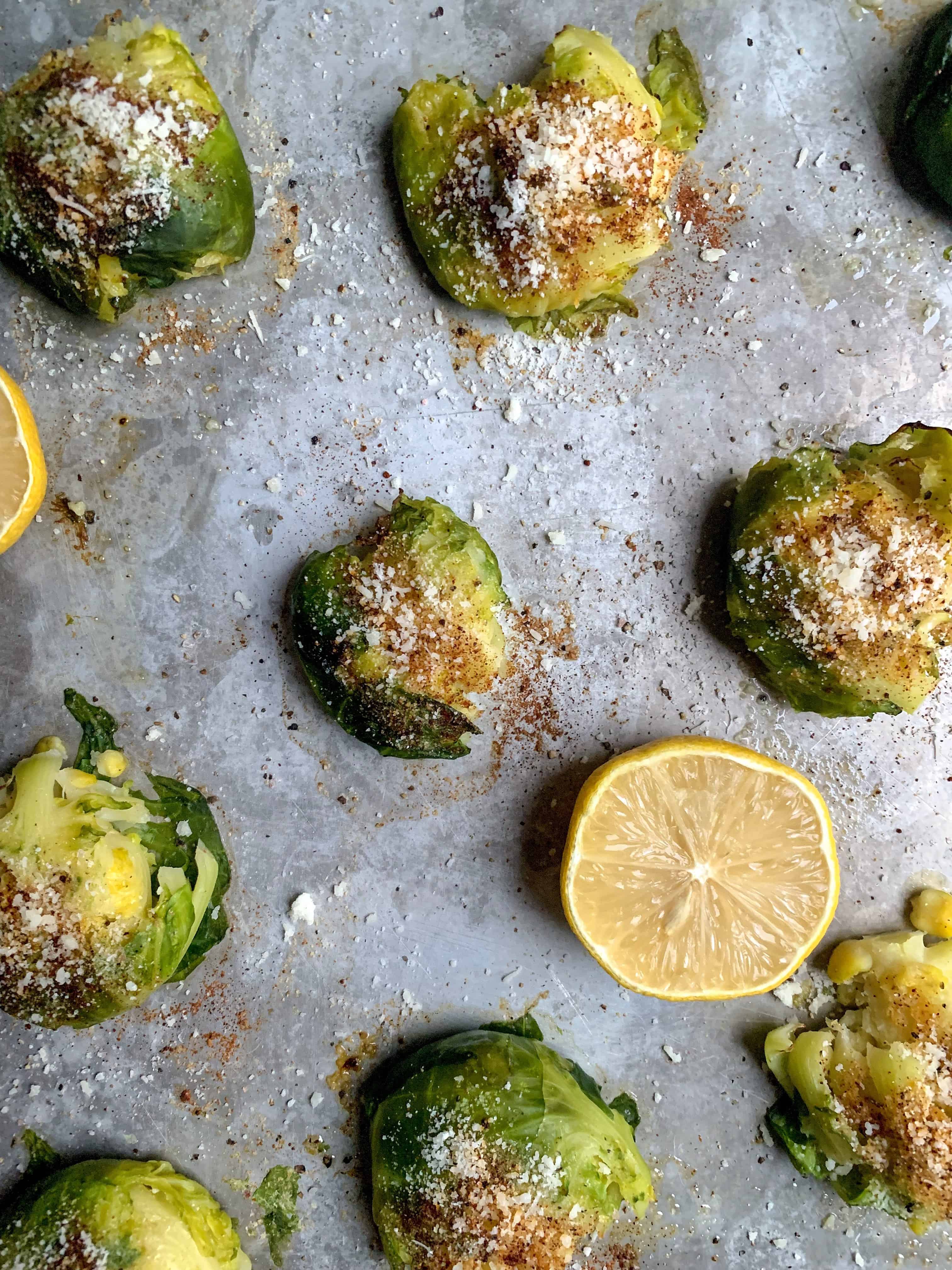 roasted brussels sprouts on sheet pan with half a lemon.