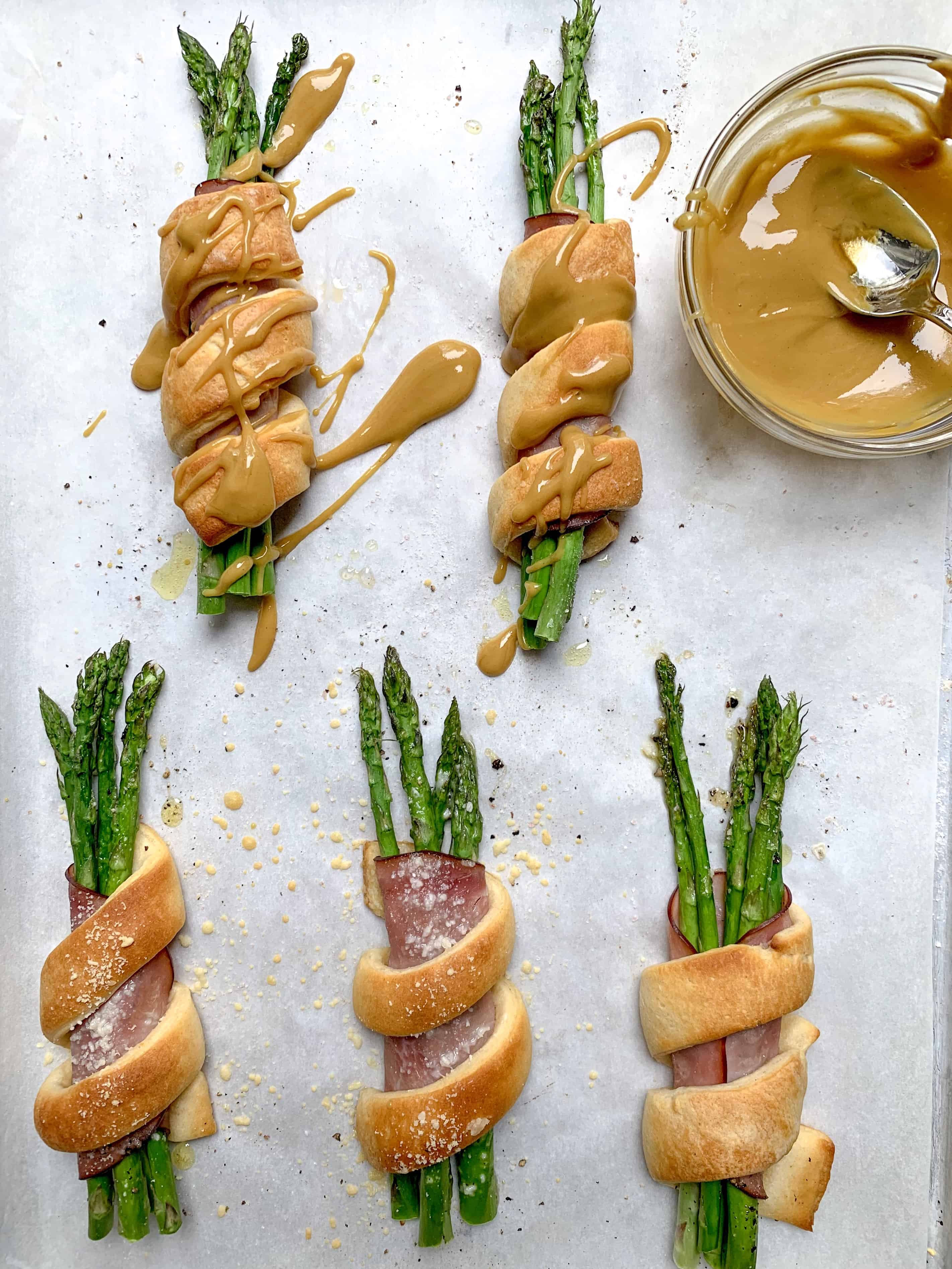 up close of 5 asparagus bundles with bowl with honey mustard inside