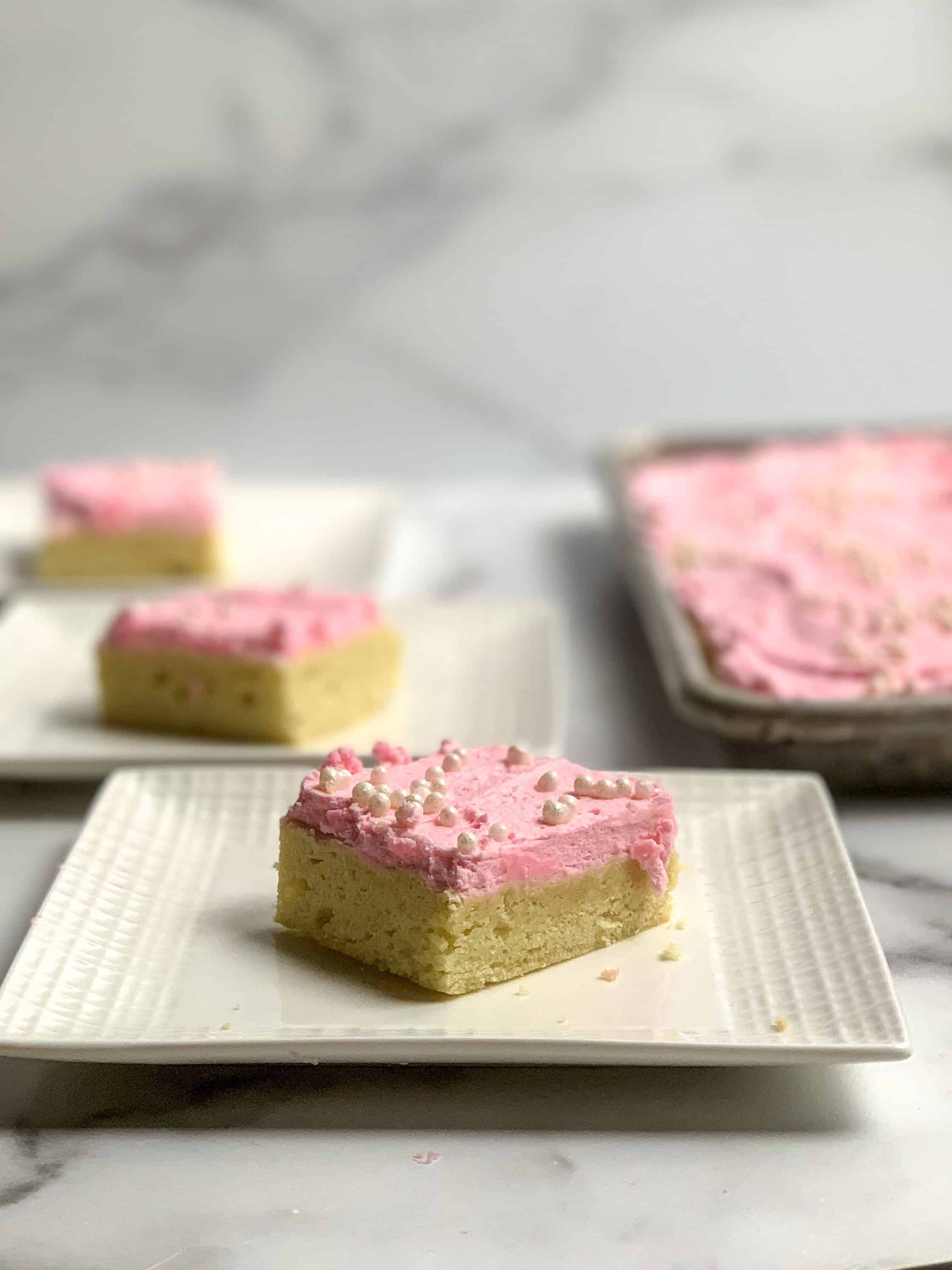 cut sugar cookie bars with fluffy frosting