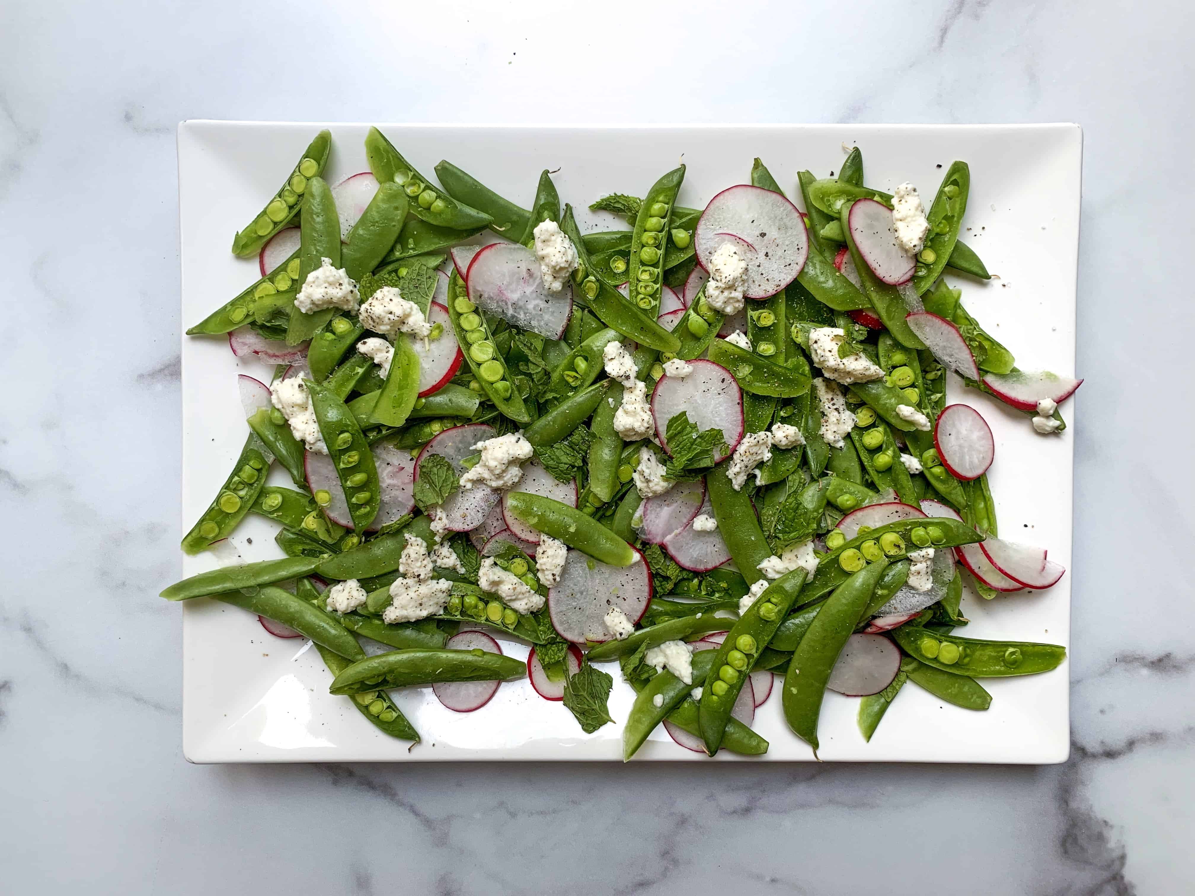 Sugar snap pea salad with shaved onion, radish, basil, and mint