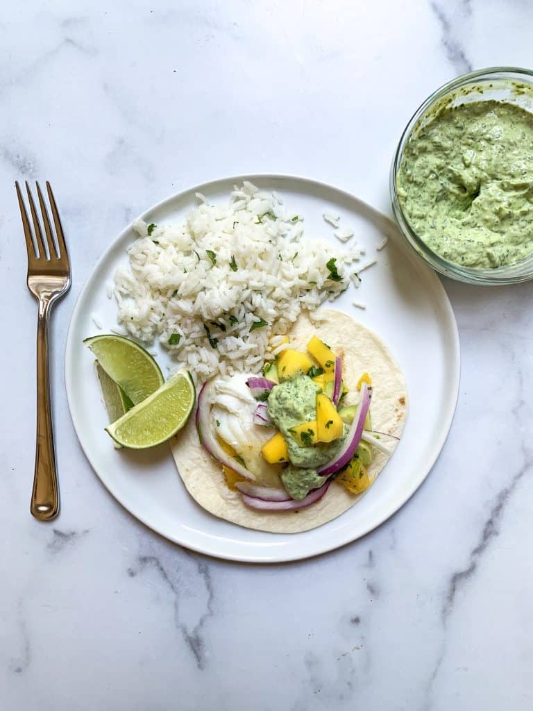 dinner plate with fish tacos and avocado crema