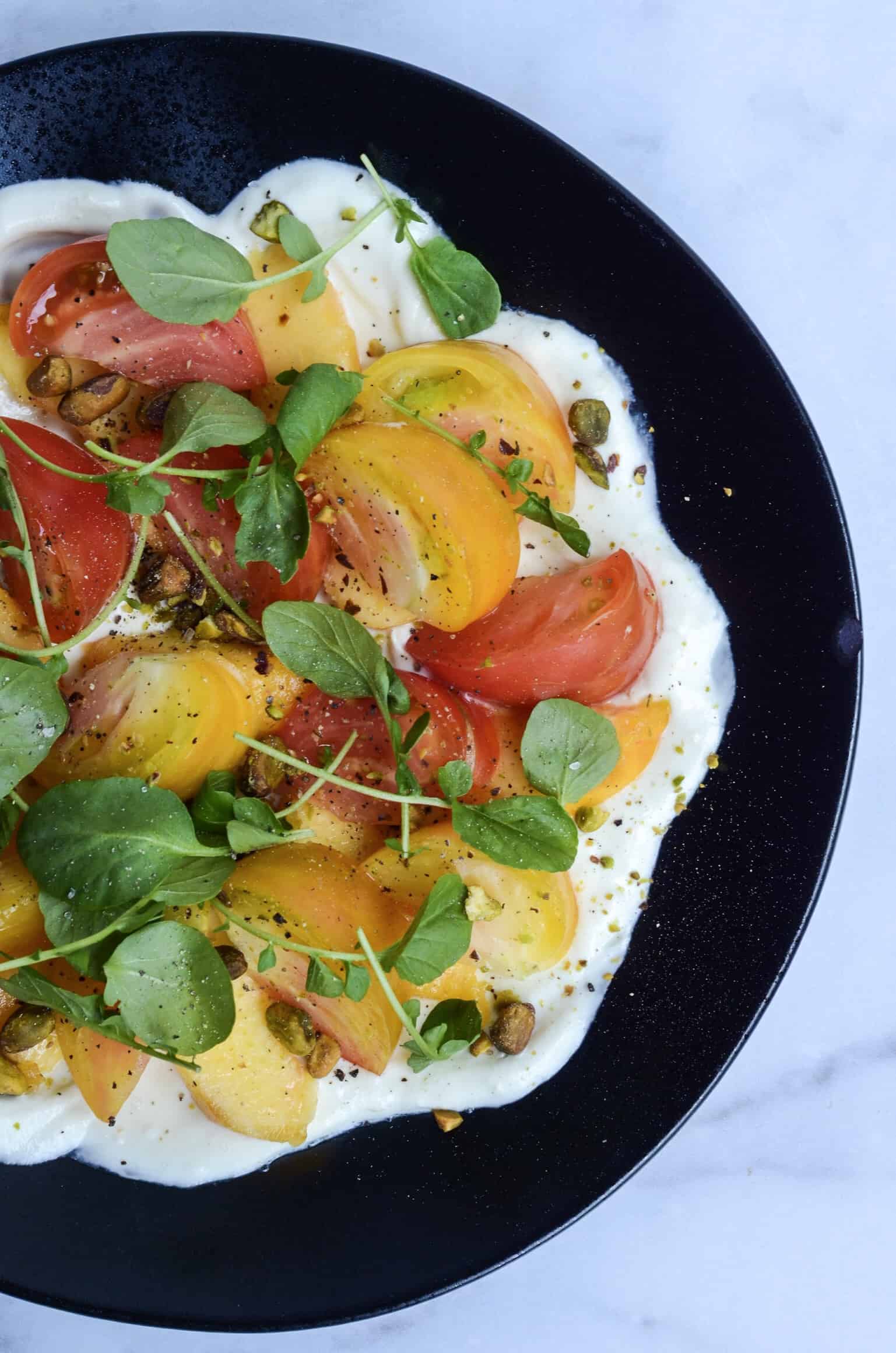 close up of tomato and peach salad with whipped goat cheese 