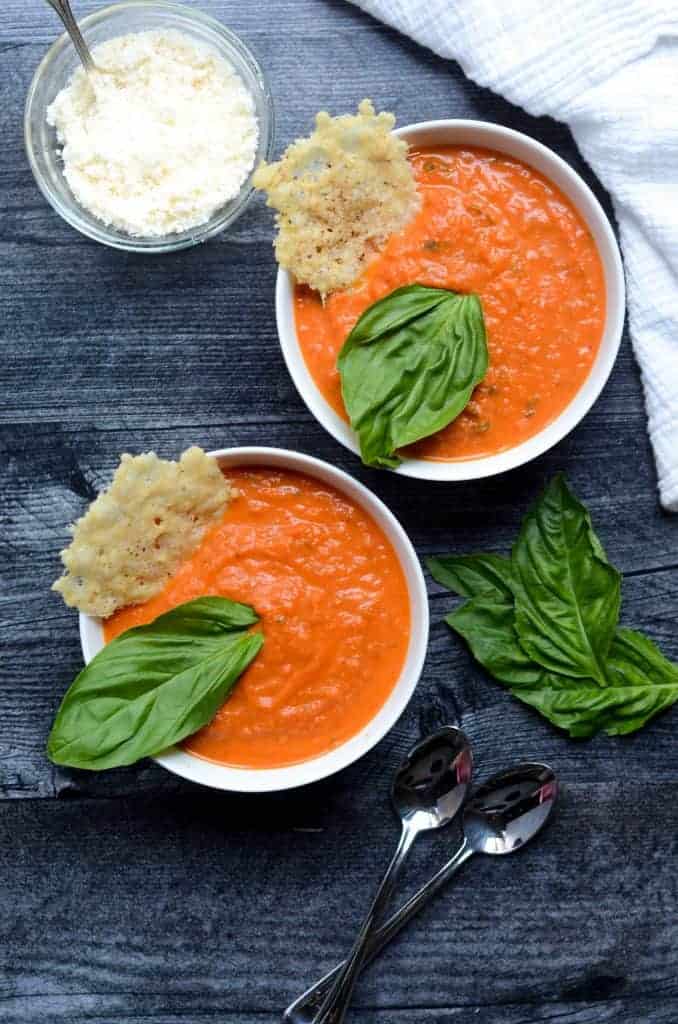 Creamy Tomato Soup with Parmesan and Basil on a White Plate