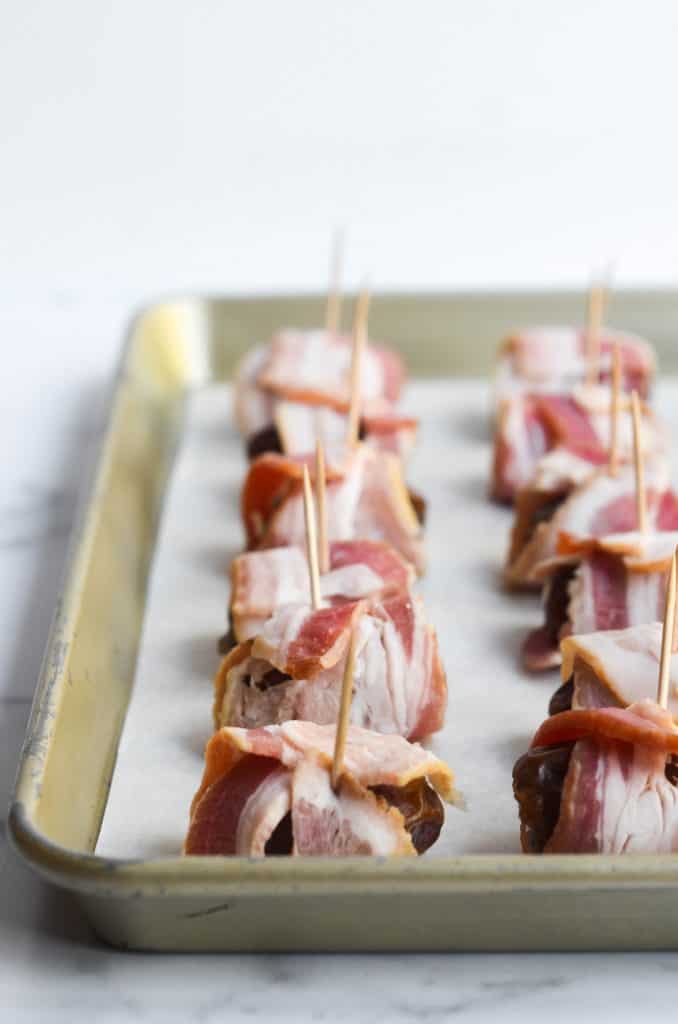 side view of bacon wrapped dates with toothpicks in them