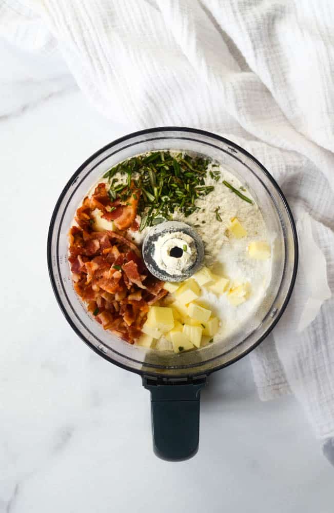 all ingredients needed to make rosemary and bacon biscuits in a food processor