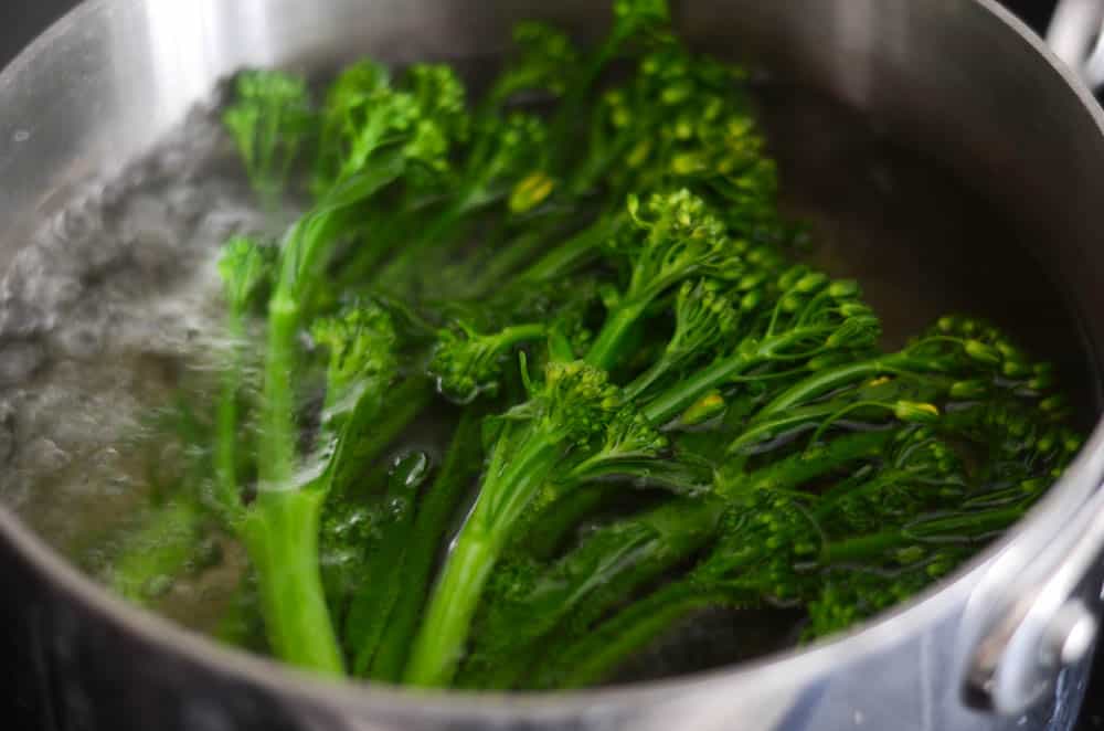 picture of broccolini getting boiled in a pot 