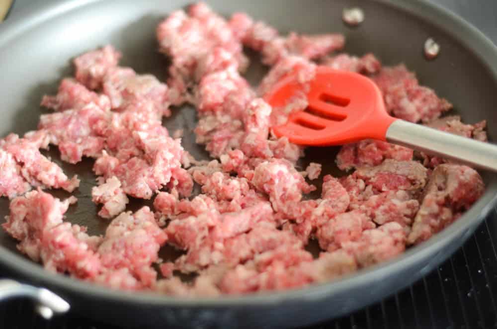 sausage being cooked in black pan