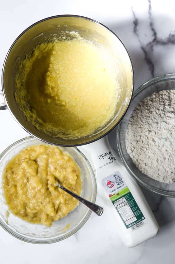 three bowls: one with wet ingredients, dry ingredients, and mashed up bananas