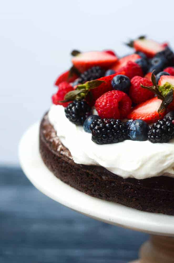 up close picture of brownie pizza with mixed berries and of whipped cream