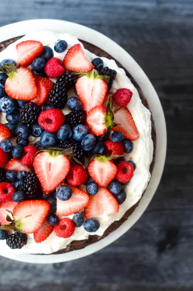 aerial view of mixed berries on top of brownie pizza against black background