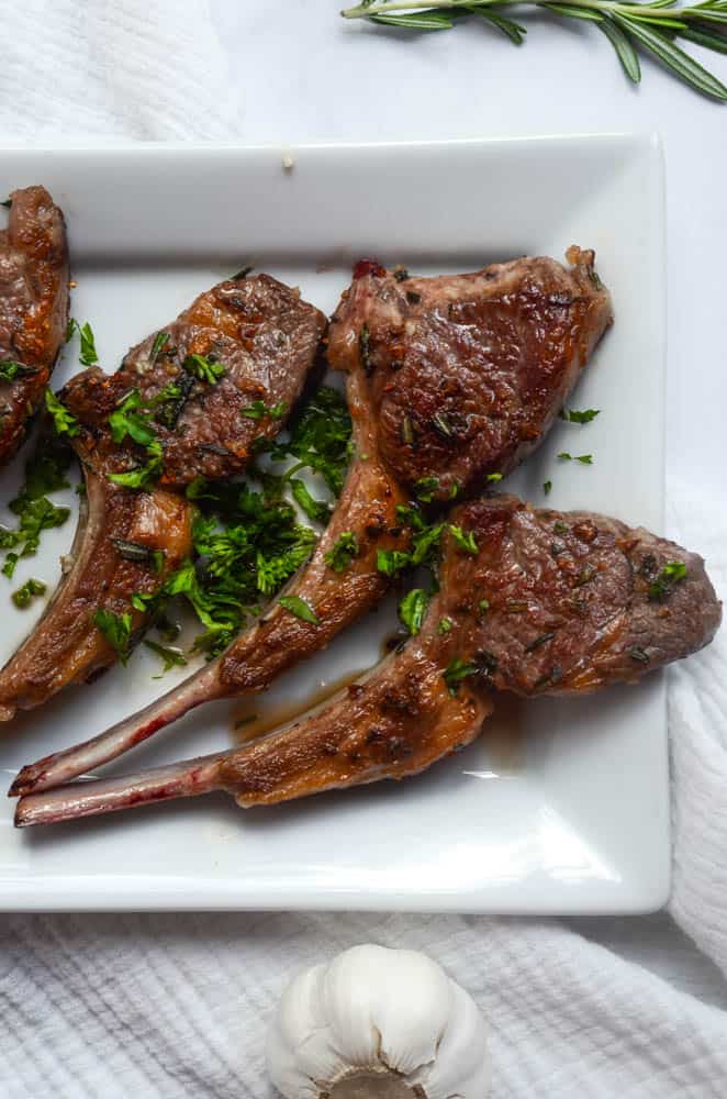 up close aerial picture of 3 lamb chops sprinkled with parsley