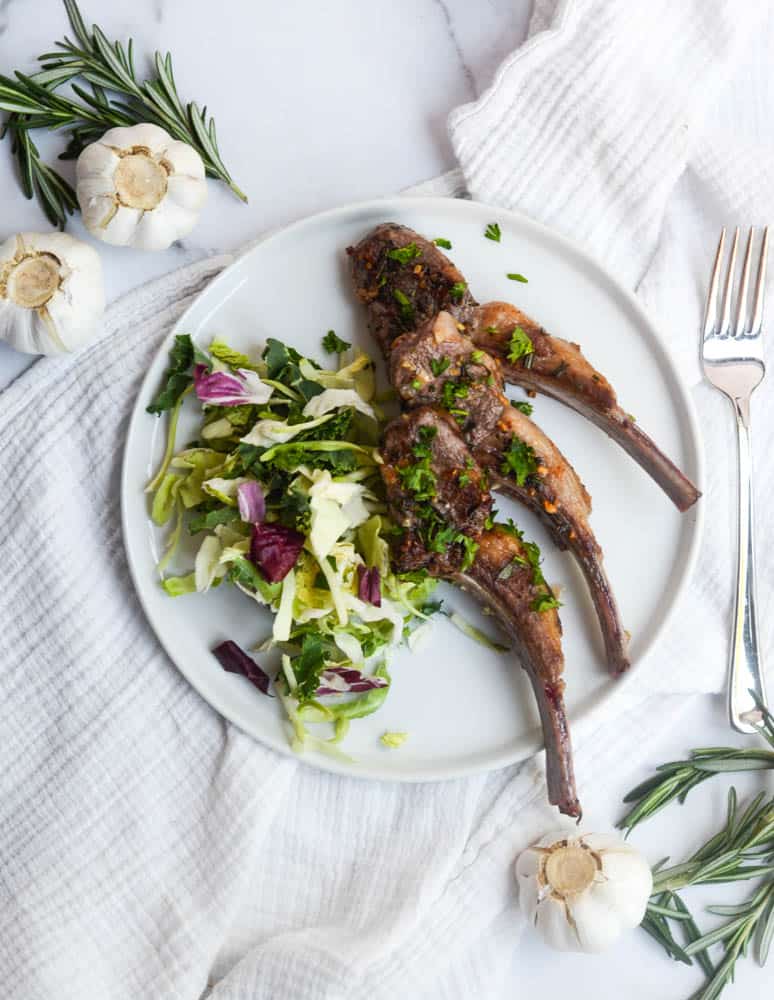 aerial view of full plate with rosemary and garlic lamb chops with side salad