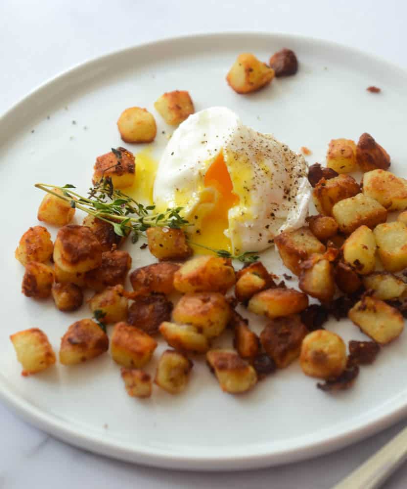 up close picture of southern fried potatoes with poached egg 