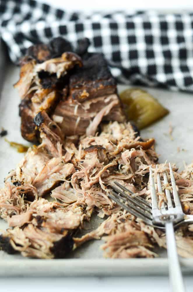 up close picture of shredded pulled pork with two messy forks