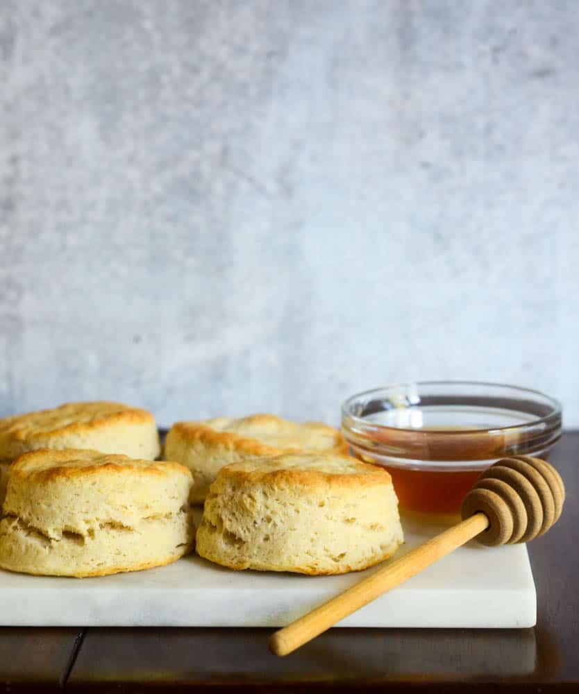 biscuits on marble slab with bowl of honey and honey comb. 