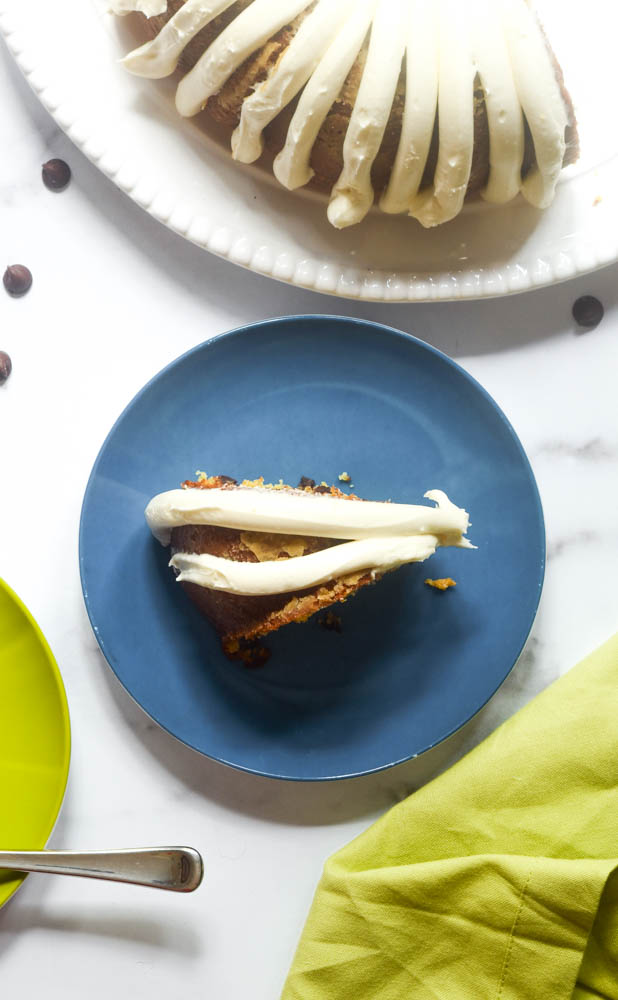 aerial shot of one slice of cake on blue plate with green napkin and remainder of cake above