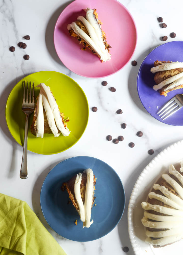 aerial picture of slices of cake on brightly colored plates with forks and chocolate chips scattered