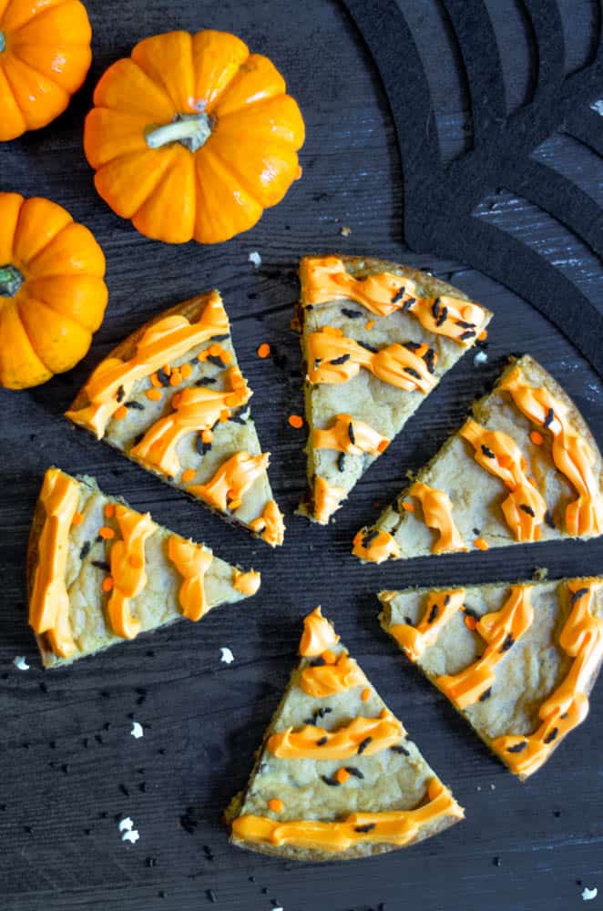 slices of cookie cake on black back drop with one slice missing.