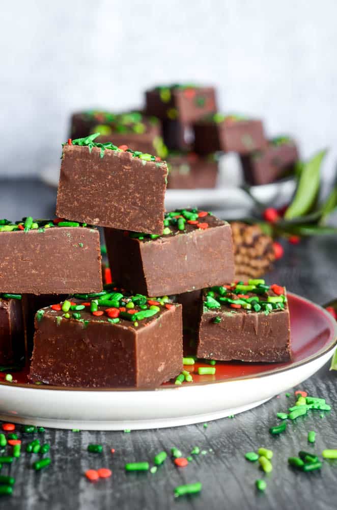 side shot of chocolate fudge stacked up in a pyramid on a small red plate. 