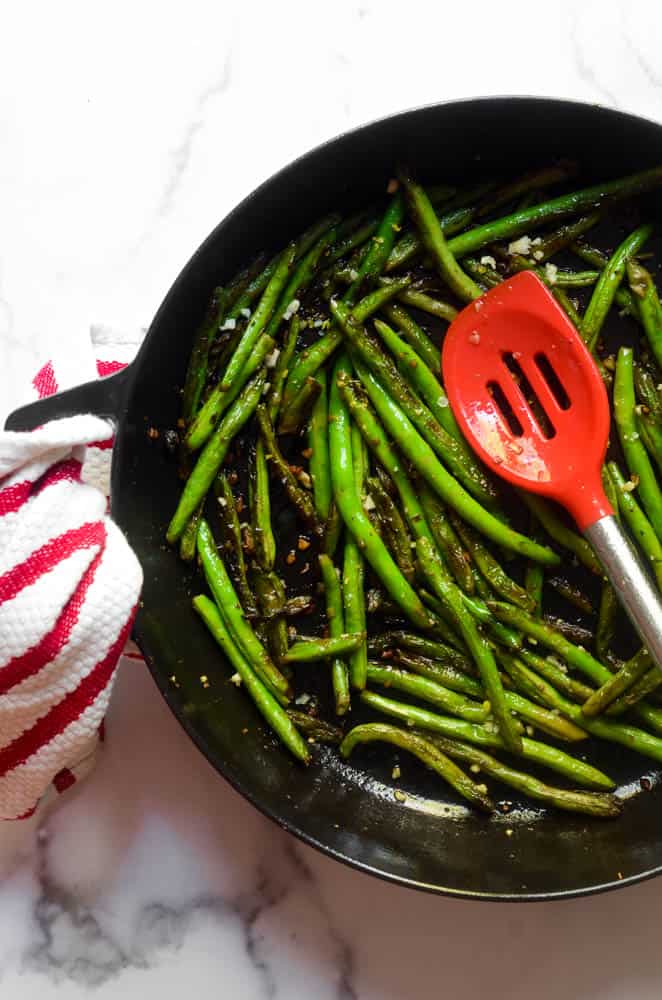 aerial picture of green beans sautéing in cast iron skillet