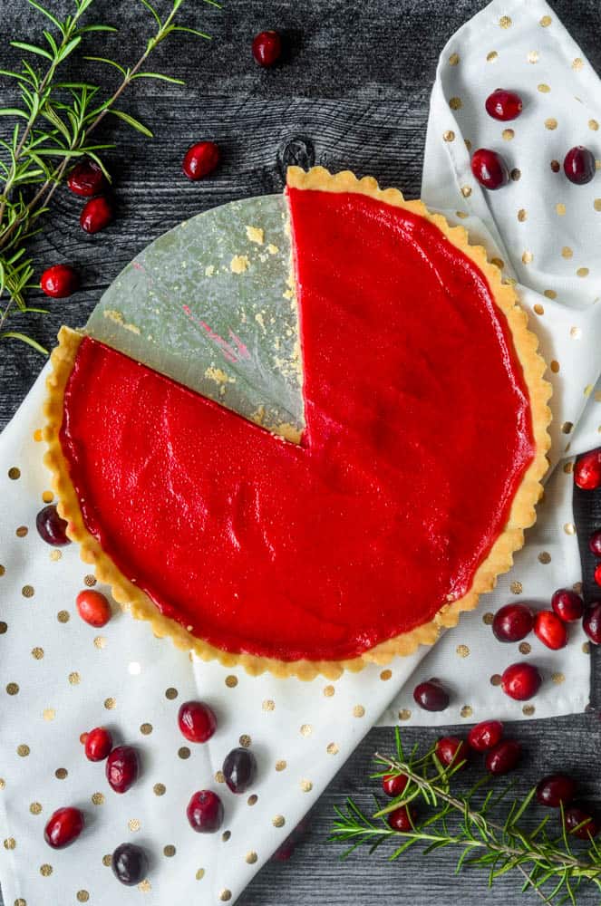 cranberry curd tart with once large slice cut from it. 