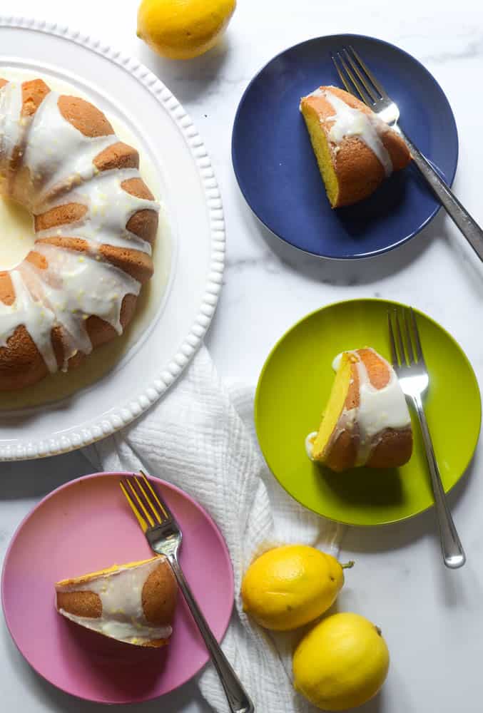 aerial picture of bundt cake slices on colorful round plates and full bundt cake on large white platter.