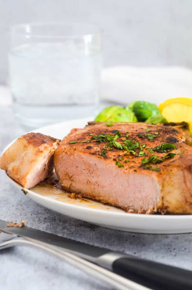 close up picture of a pork chop that's been cut into. 