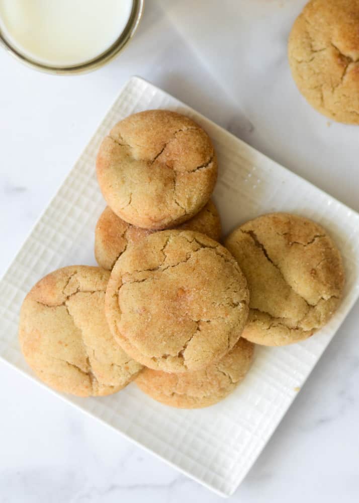 stack of snickerdoodle cookies on white square plate.