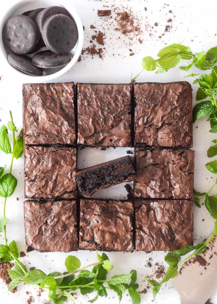 aerial photo of brownies cut into 9 pieces with the middle piece turned so you can see the fudgy interior. 