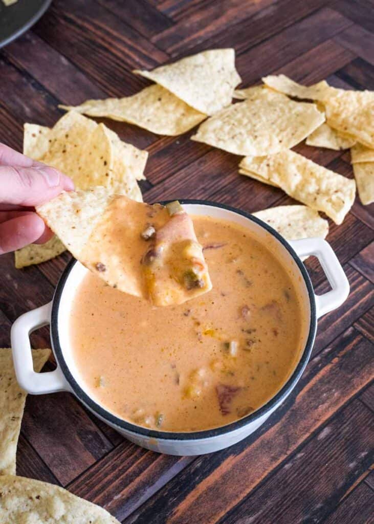 picture of a chip being dipped in cheese dip. 