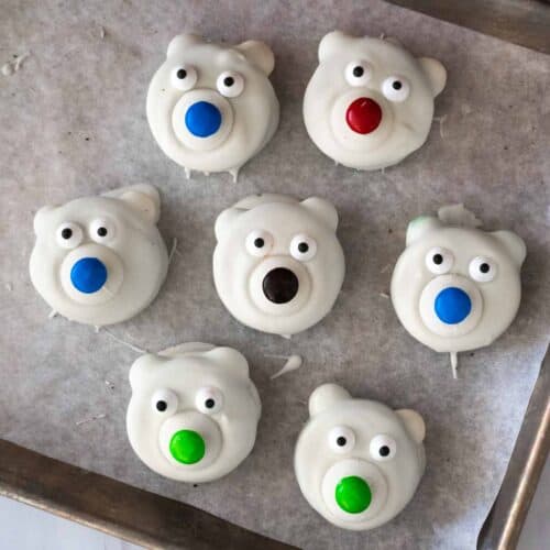 Flat lay picture of polar bear Oreos on parchment lined baking tray.