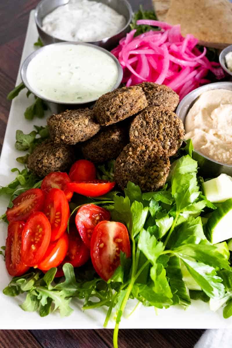 close up picture of falafel, tomatoes, and fresh cilantro. 