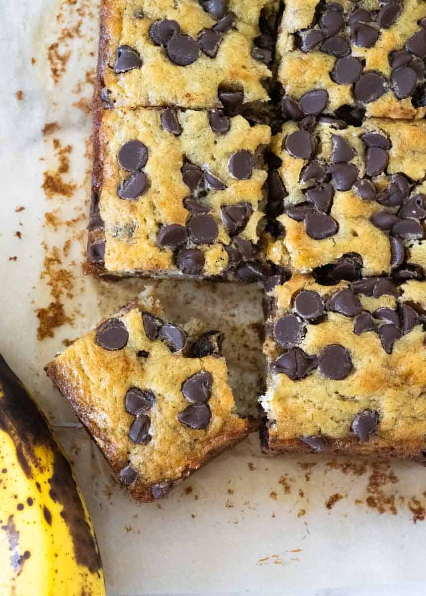 Close up of banana chocolate chip cake with one corner piece being cut out and slightly turned to see the bite marks on it. 