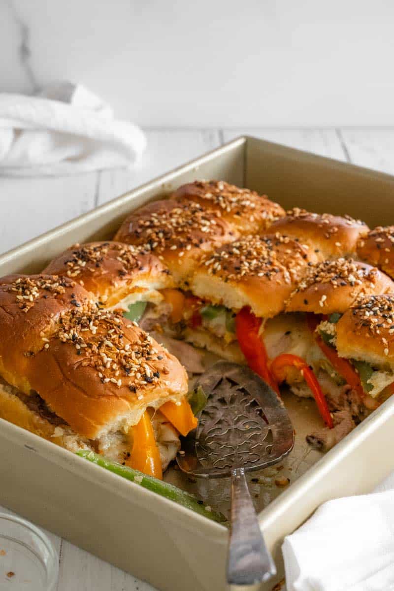 A gold pan of Roast Beef Sliders, showing the middle of the sandwiches since some have already been removed.  