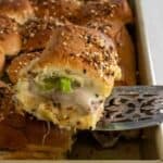 Up close picture of a roast beef slider on a serving spatula.