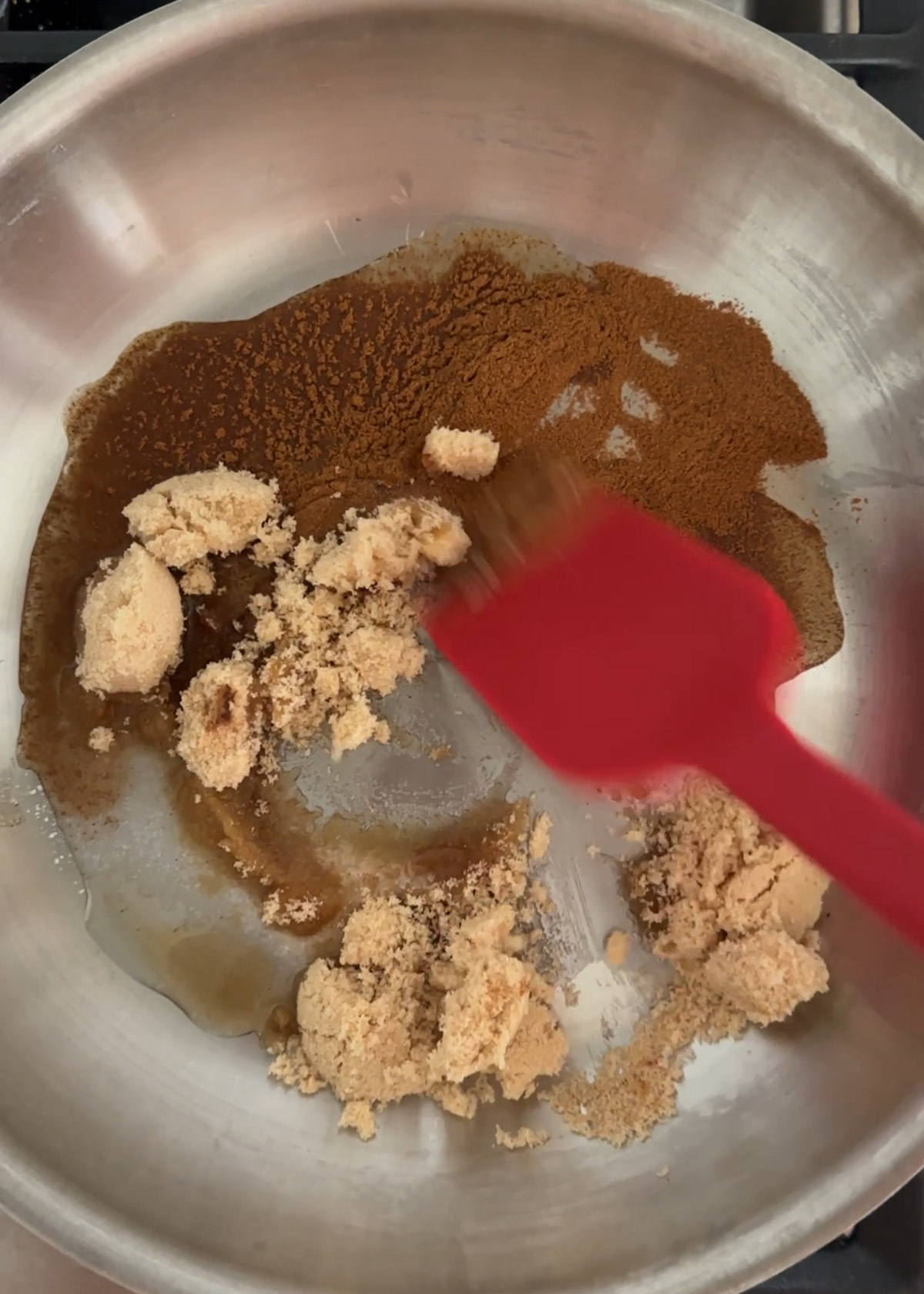 Step 1 in the series on how to make candied pecans with all of the ingredients except pecans being combined in a stainless steel frying pan. 