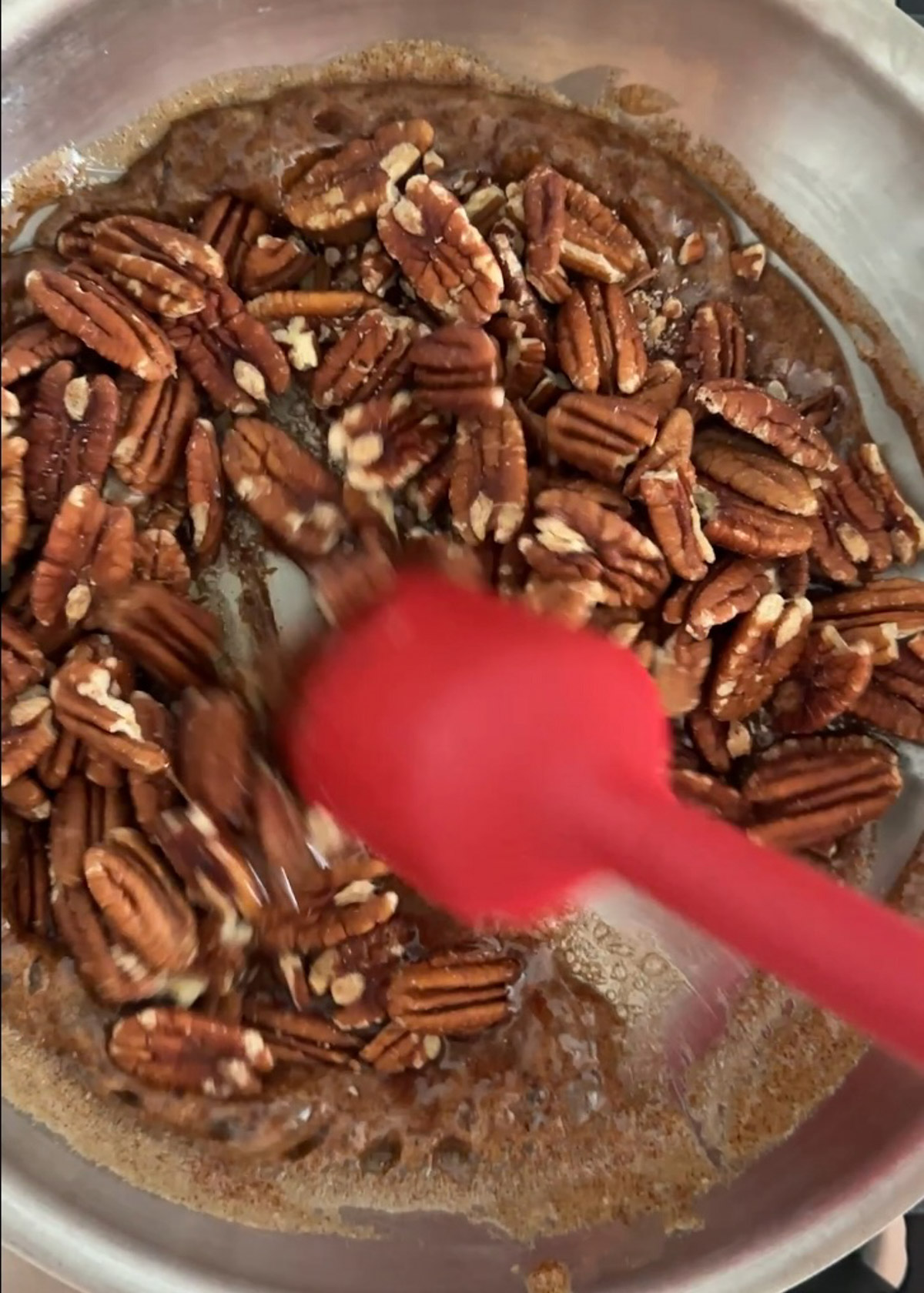 Step 3 in series that shows pecans being tossed in the brown sugar mixture. 