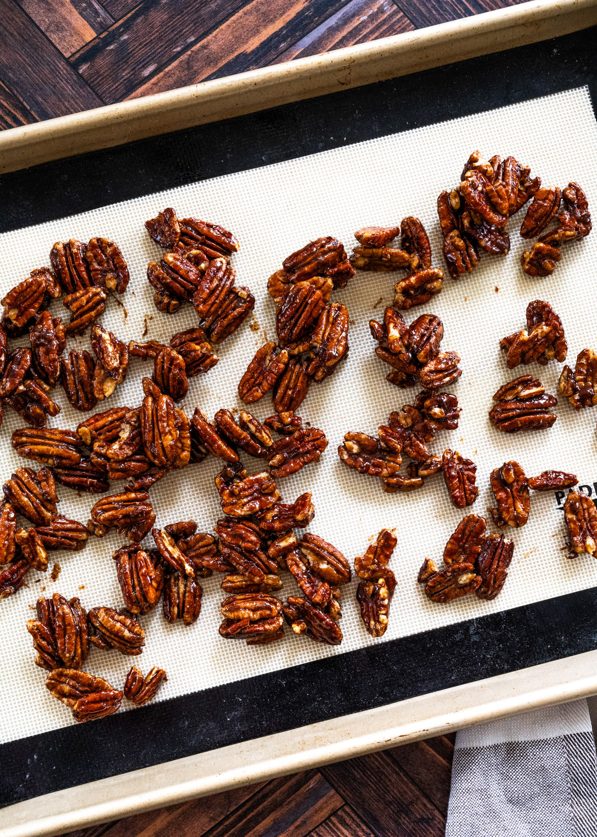 Step 4 in the series that shows pecans spread out in a single layer on a baking mat. 
