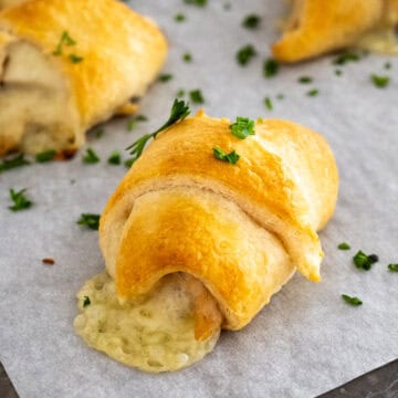 close up of a turkey and cheese crescent roll with the Swiss cheese oozing from the side.