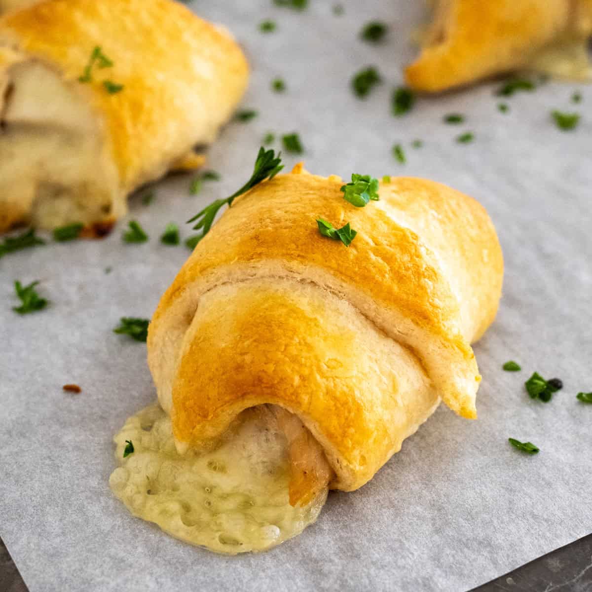 close up of a turkey and cheese crescent roll with the Swiss cheese oozing from the side.