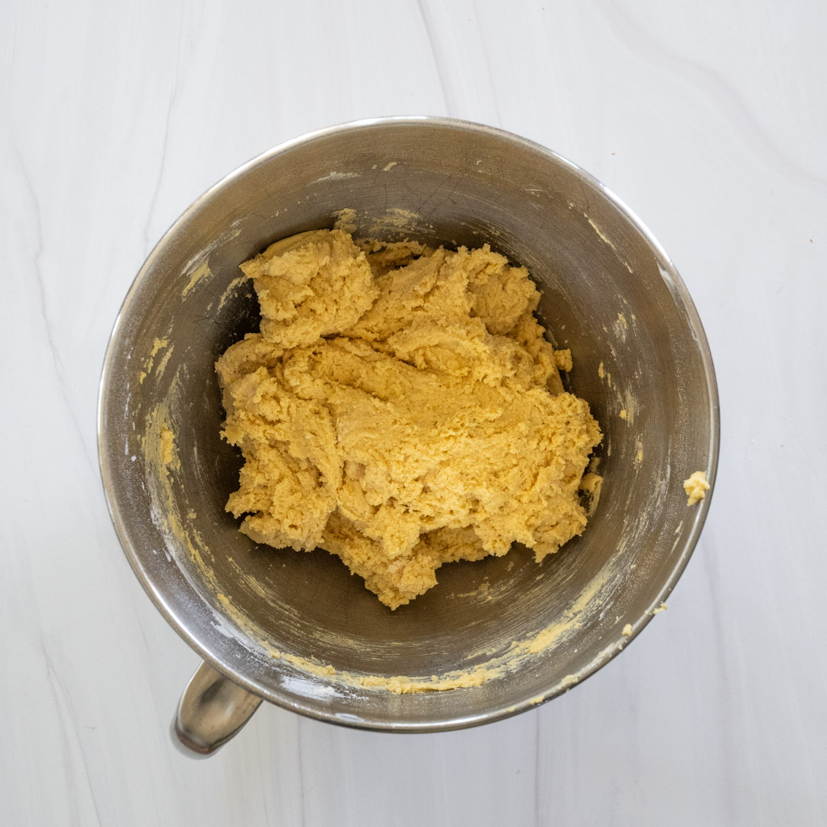 step 4 showing the dry ingredients combined with the wet ingredients in a stand mixer bowl. 