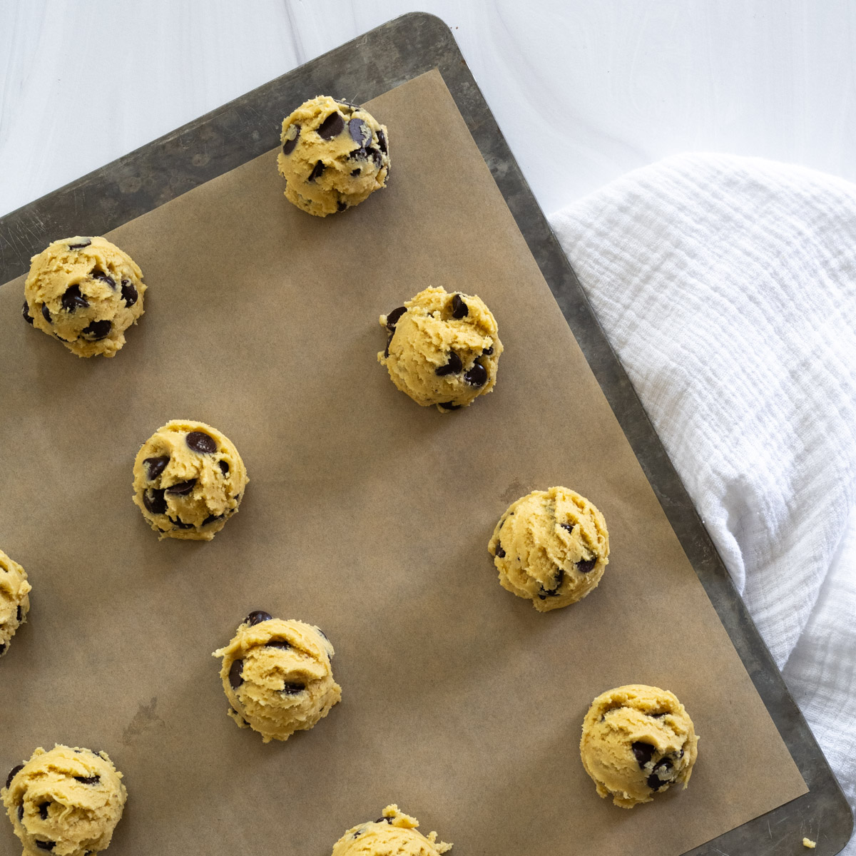 step 6 showing balls of dough placed on a baking tray lined with parchment paper. 