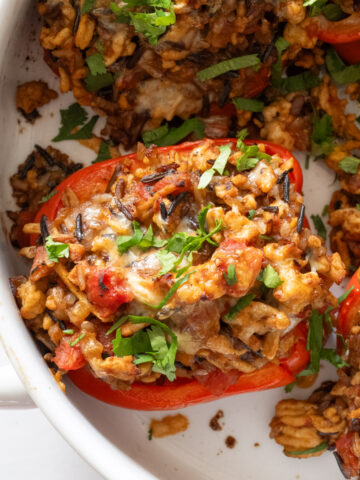 Close up of a ground turkey stuffed pepper with melty cheese and cilantro on top.