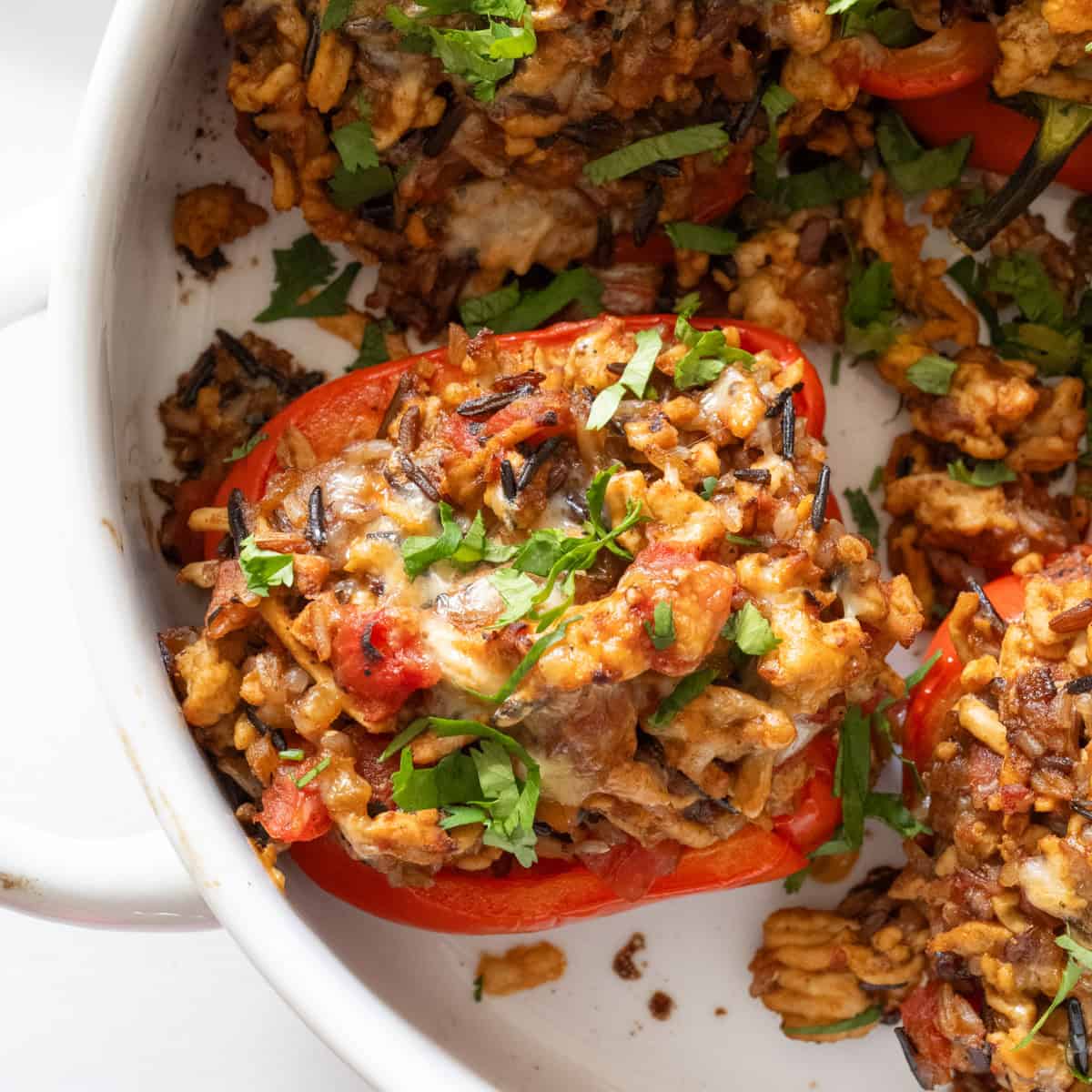 Close up of a ground turkey stuffed pepper with melty cheese and cilantro on top.