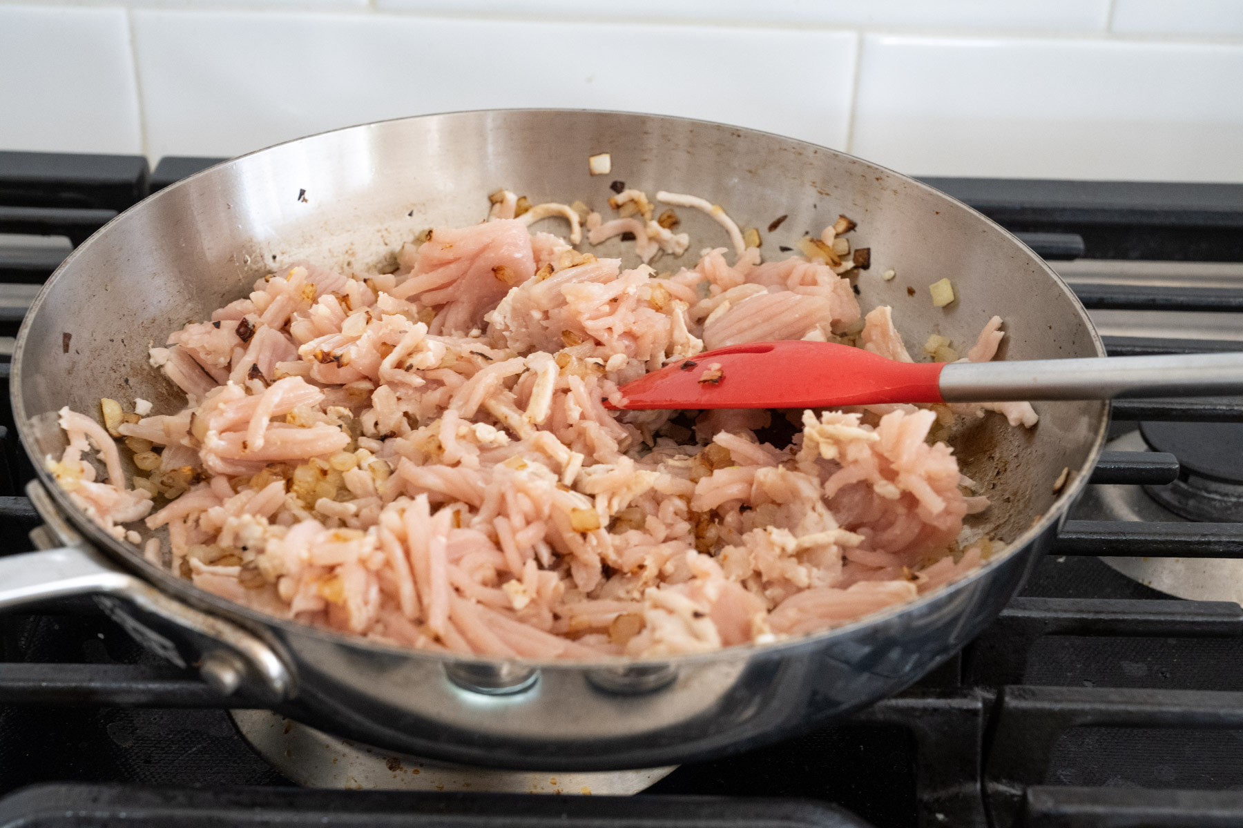 Step 4 of the directions showing raw ground turkey added to the pan. 