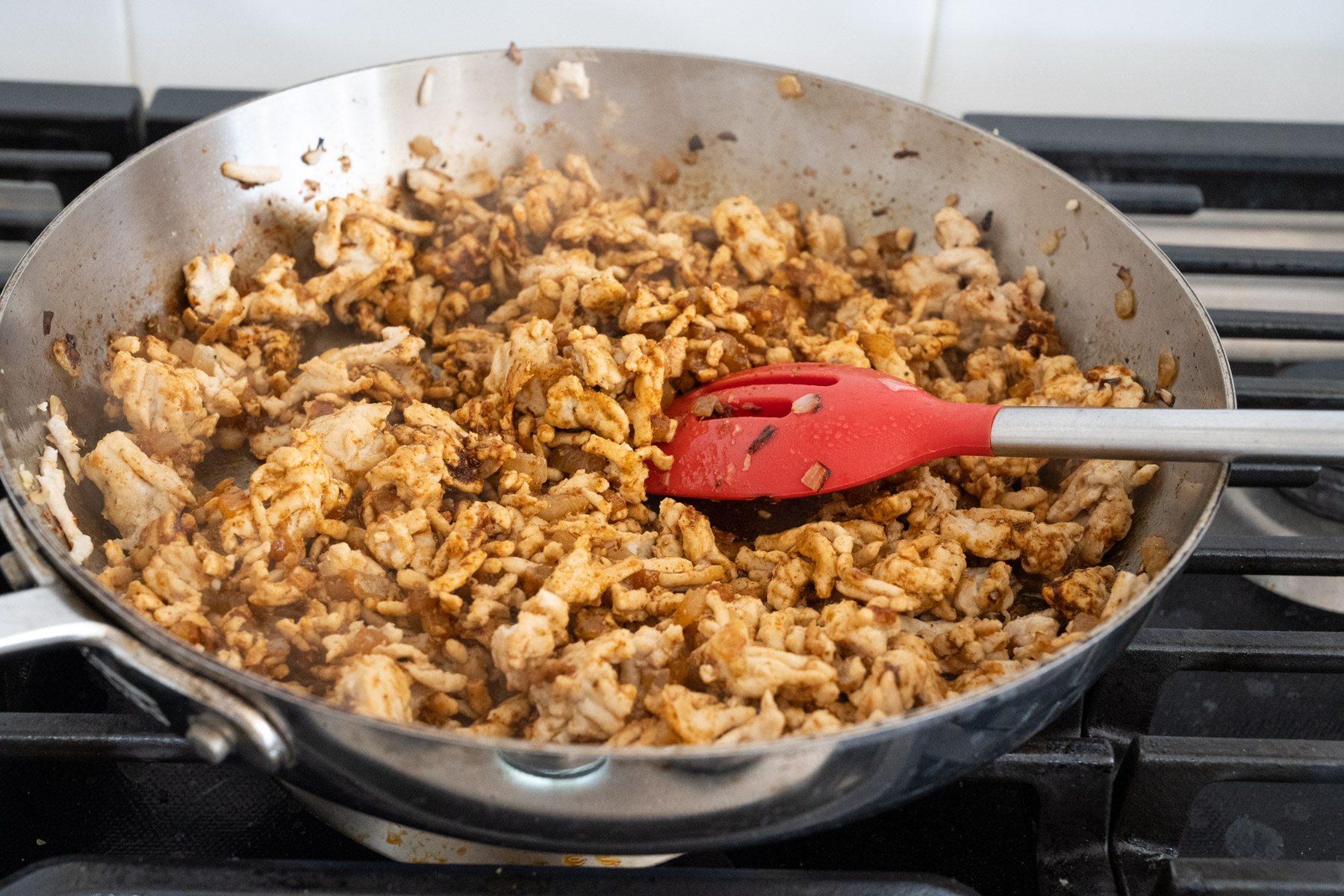 Step 5 of the directions showing ground turkey seasoned with spices in the pan. 
