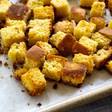 Side, up-close view of cornbread croutons after coming out of the oven.